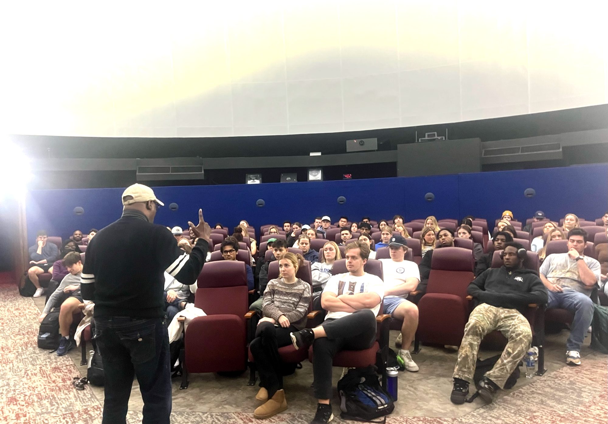 Bernard Bell teaching a full room at UNC's planetarium